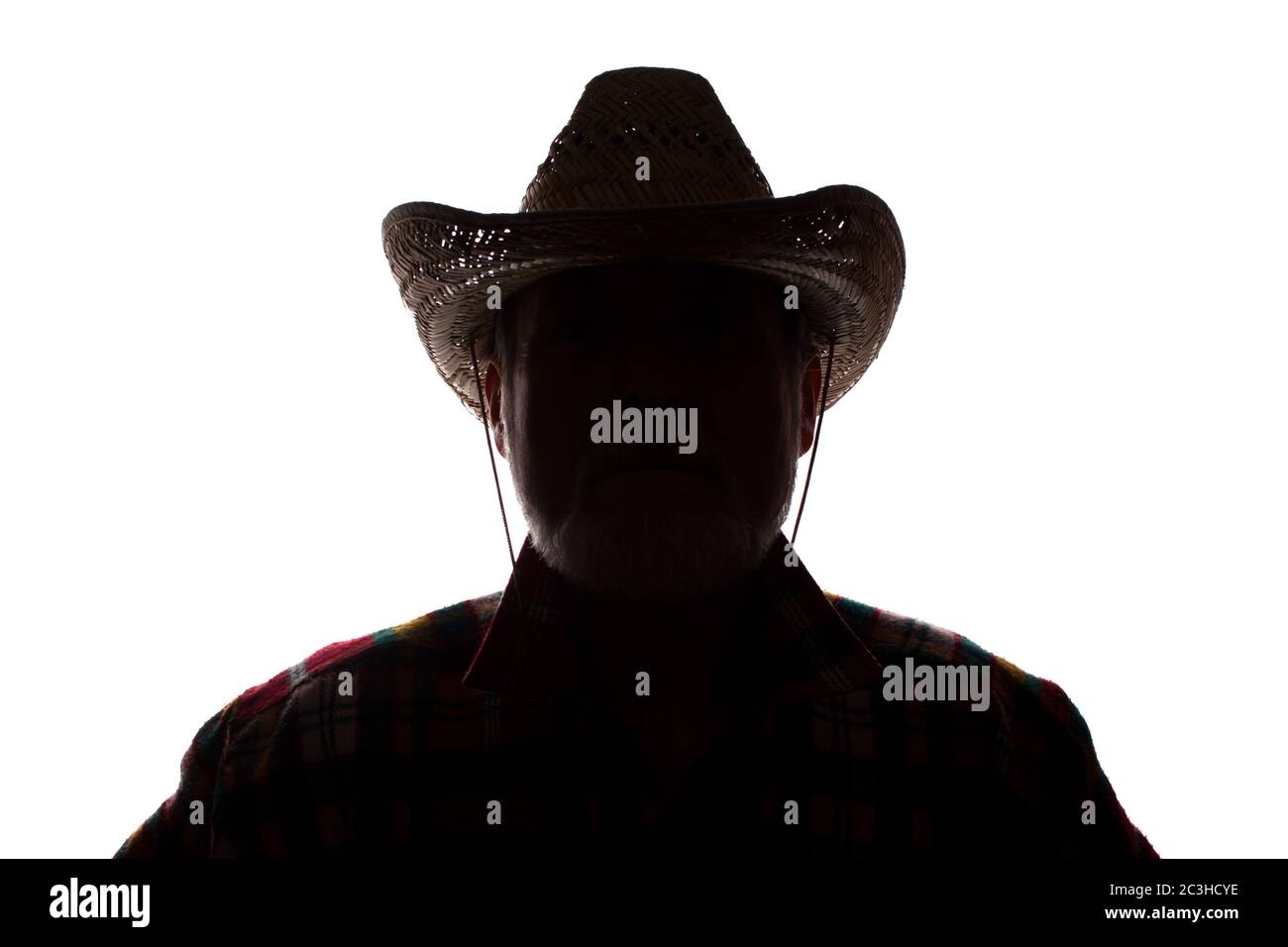 Porträt eines alten Mannes, in einem Cowboy-Hut, mit Bart, Vorderansicht - dunkel isoliert Silhouette Stockfoto