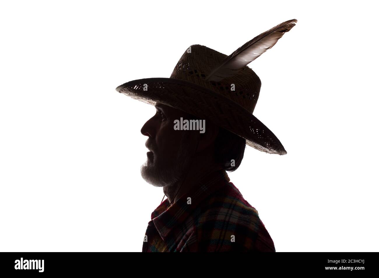 Porträt eines alten Mannes, in einem Cowboy Hut mit Feder, mit Bart, Seitenansicht - dunkel isoliert Silhouette Stockfoto