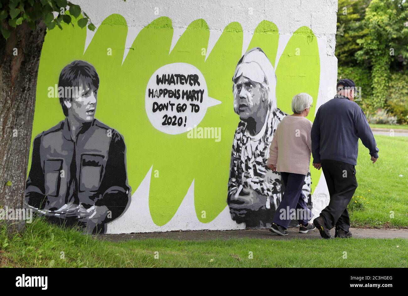 Die Menschen laufen an dem Wandbild der irischen Künstlerin Emmalene Blake vorbei, das die Figuren Marty McFly und Doc Brown aus dem Kult-80er-Film 'Back to the Future' in South Dublin darstellt. Dies ist das neueste Coronavirus-Wandbild des Künstlers in Dublin während der Pandemie. Weitere Künstler waren Dua Lipa, Robyn und Cardi B. Stockfoto