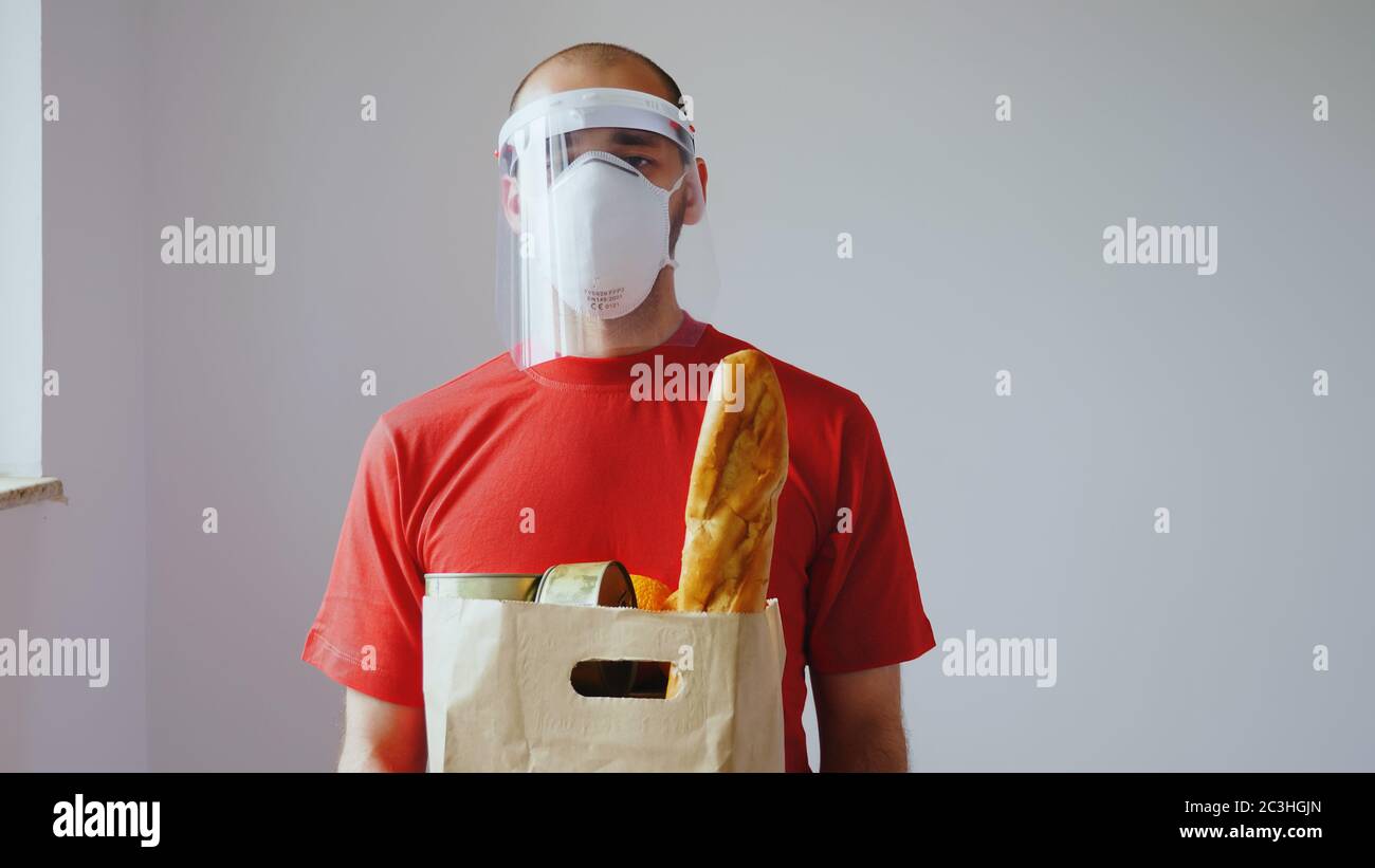 Portrait des Lieferers mit Maske während des covid-19. Stockfoto
