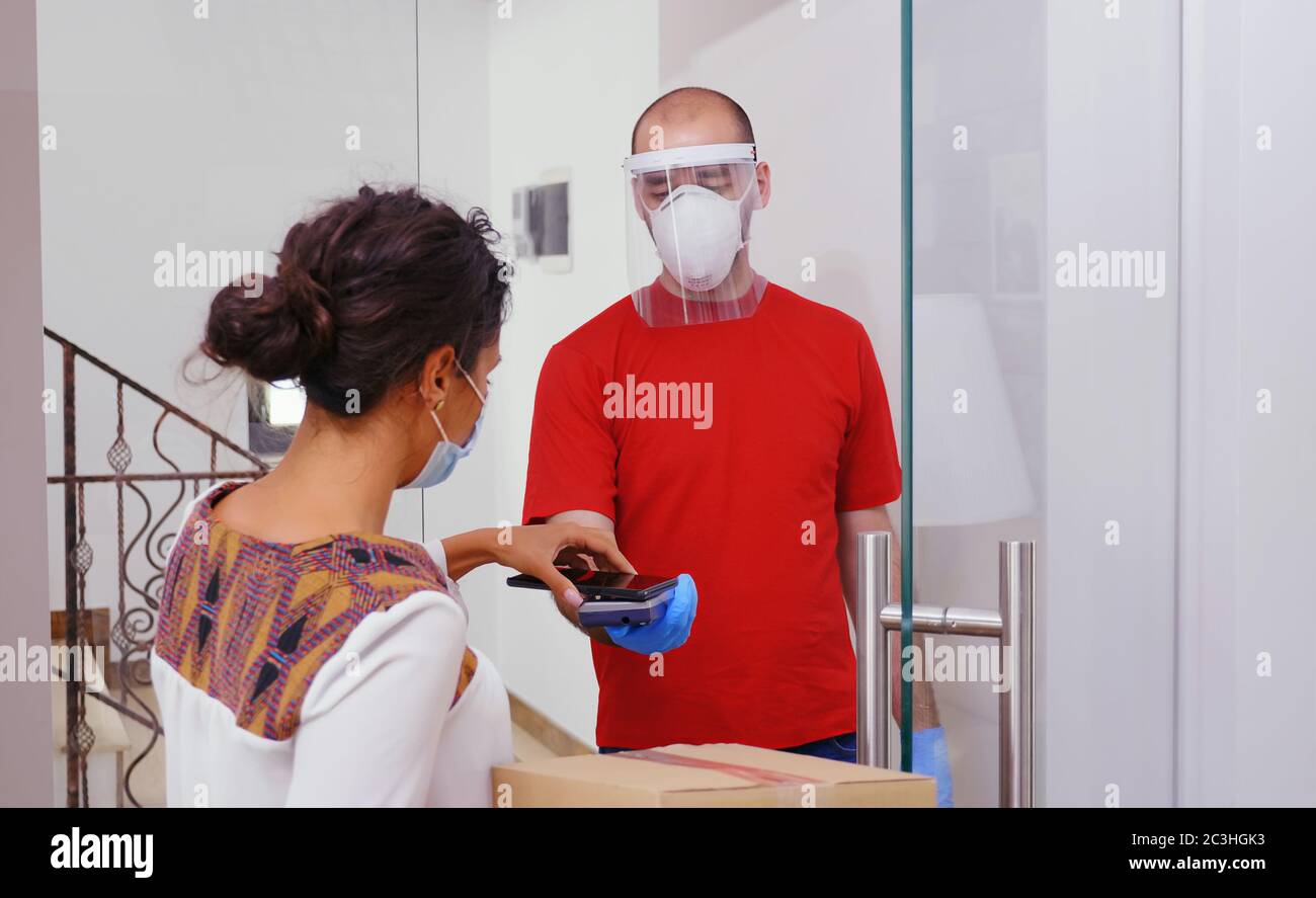 Kurier liefert Lebensmittel zu Hause während Coronavirus. Stockfoto