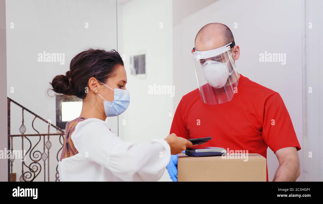 Frau, die mit Telefon-App für sie für Paketzustellung bezahlt. Stockfoto