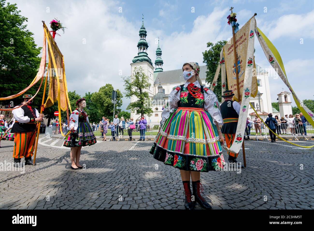 Lowicz, 11. Juni 2020: Menschen in polnischen Volkstrachten aus der Region Lowicz und Gesicht Schutzmasken während Fronleichnam Prozession. Stockfoto
