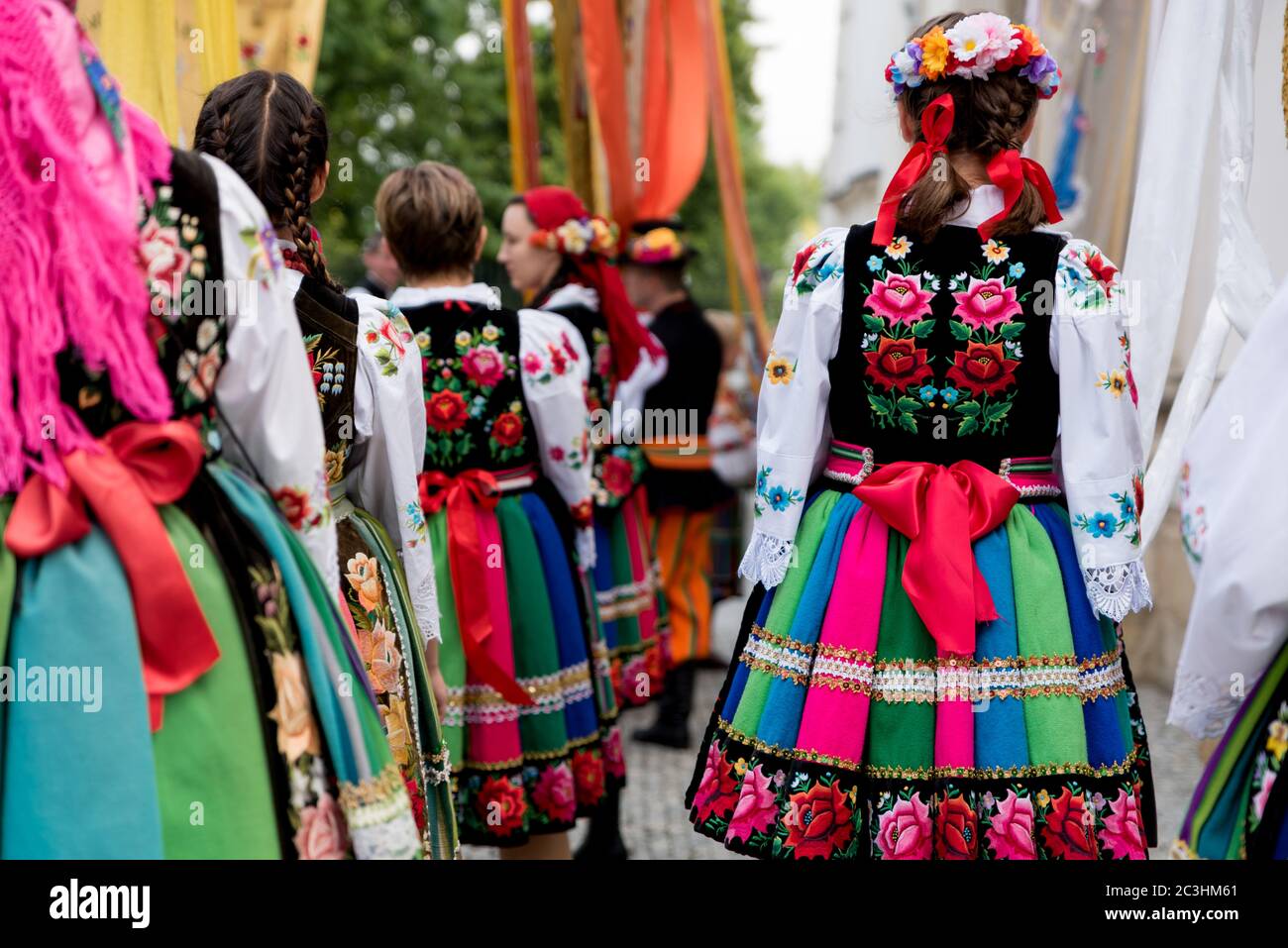 Mädchen in polnischen nationalen Volkstrachten aus der Region Lowicz während der Fronleichnamsprozession gekleidet. Traditionelle bunt gestreifte Lowicz Röcke Stockfoto
