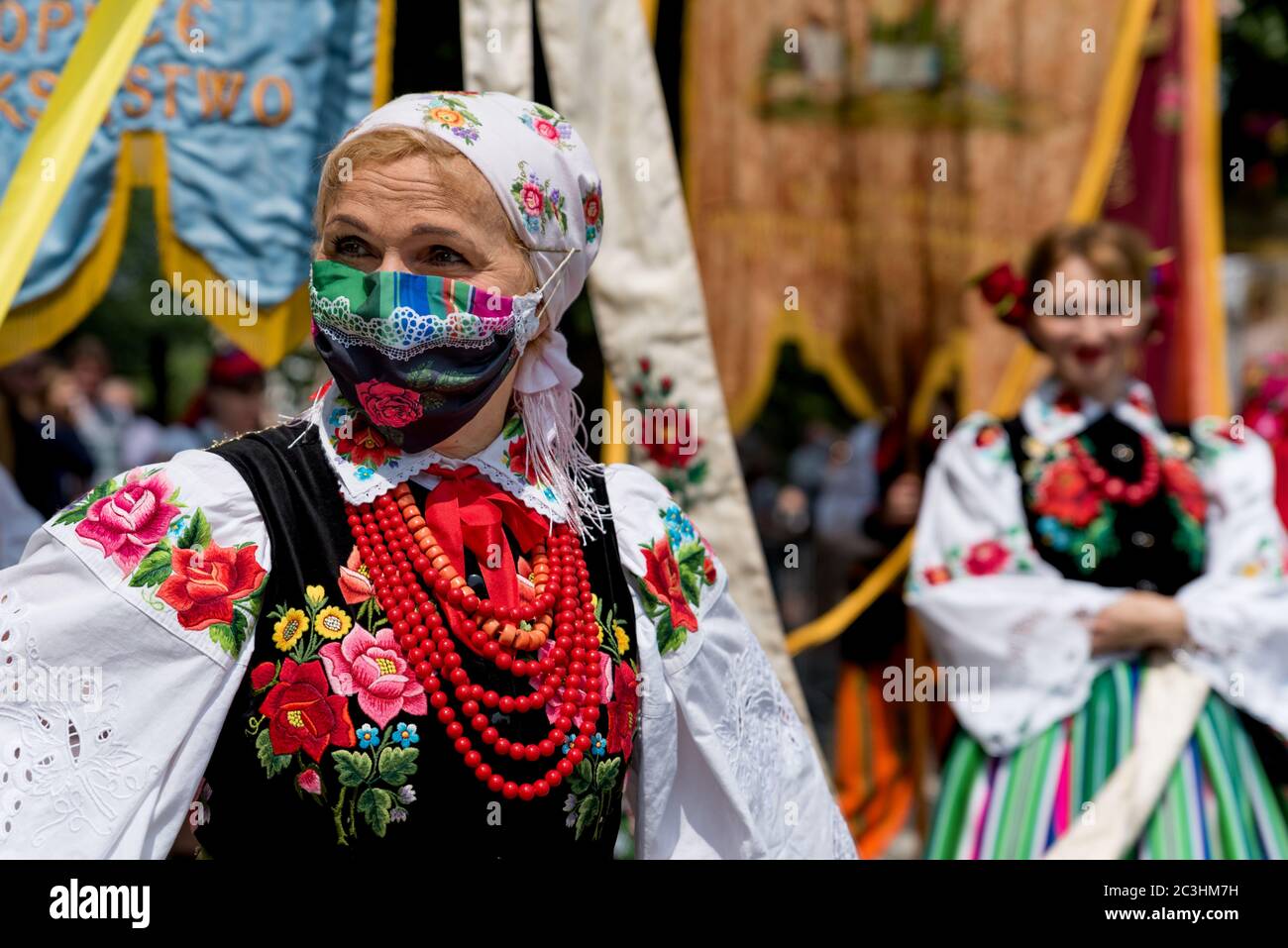 Lowicz, 11. Jun 2020: Portrait einer Frau in polnischer Volkstracht aus Lowicz und Gesichtsschutzmaske während der Fronleichnamsprozession Stockfoto