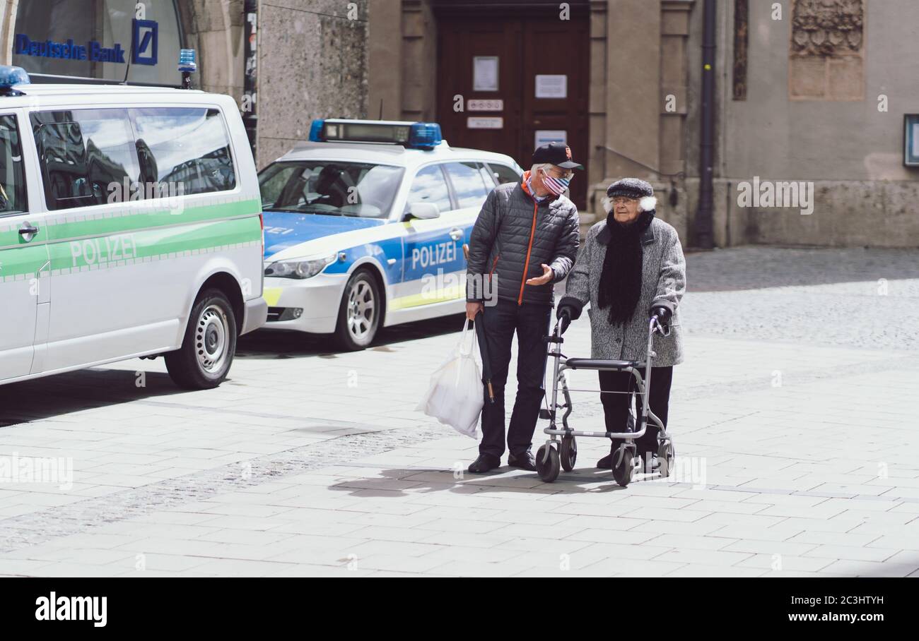 MÜNCHEN, 02. Mai 2020: Ein Seniorenpaar mit Gesichtsmasken geht durch die Münchner Innenstadt. Schutz und Angst vor dem Coronavirus. Polizeikontrolle Stockfoto