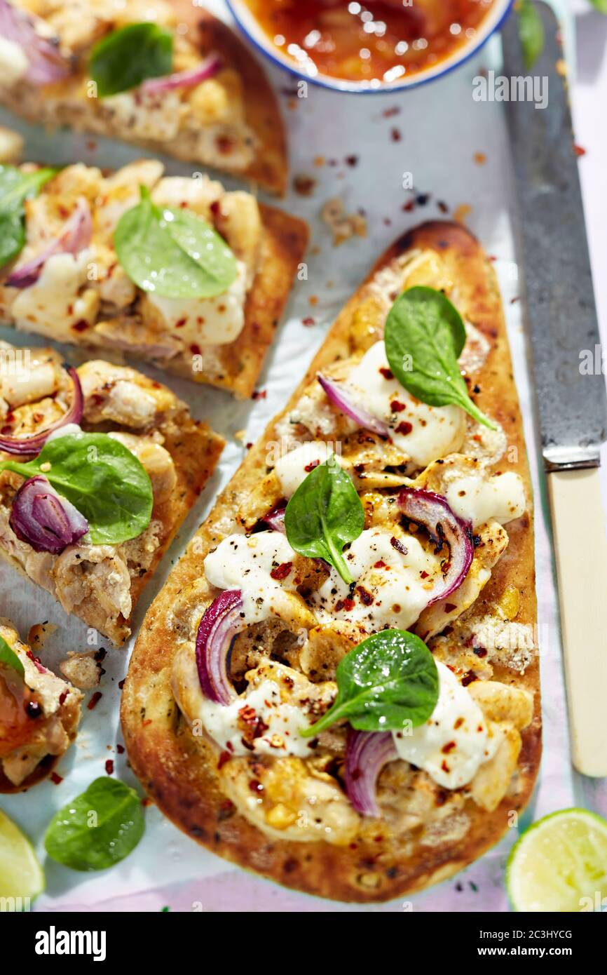 Huhn Korma Naan indisches Brot mit roten Zwiebeln, Käse und Basilikum Stockfoto