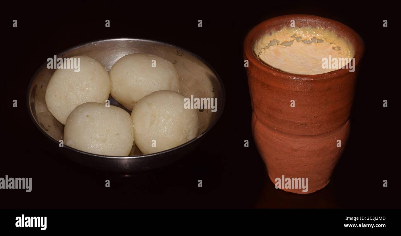 Bengali traditionelle Süßigkeiten Rosogulla oder Rasgulla (süße Hüttenkäse Kugeln) kombiniert mit Misti Doi (süßer Joghurt) isoliert auf einem dunklen Hintergrund. B Stockfoto