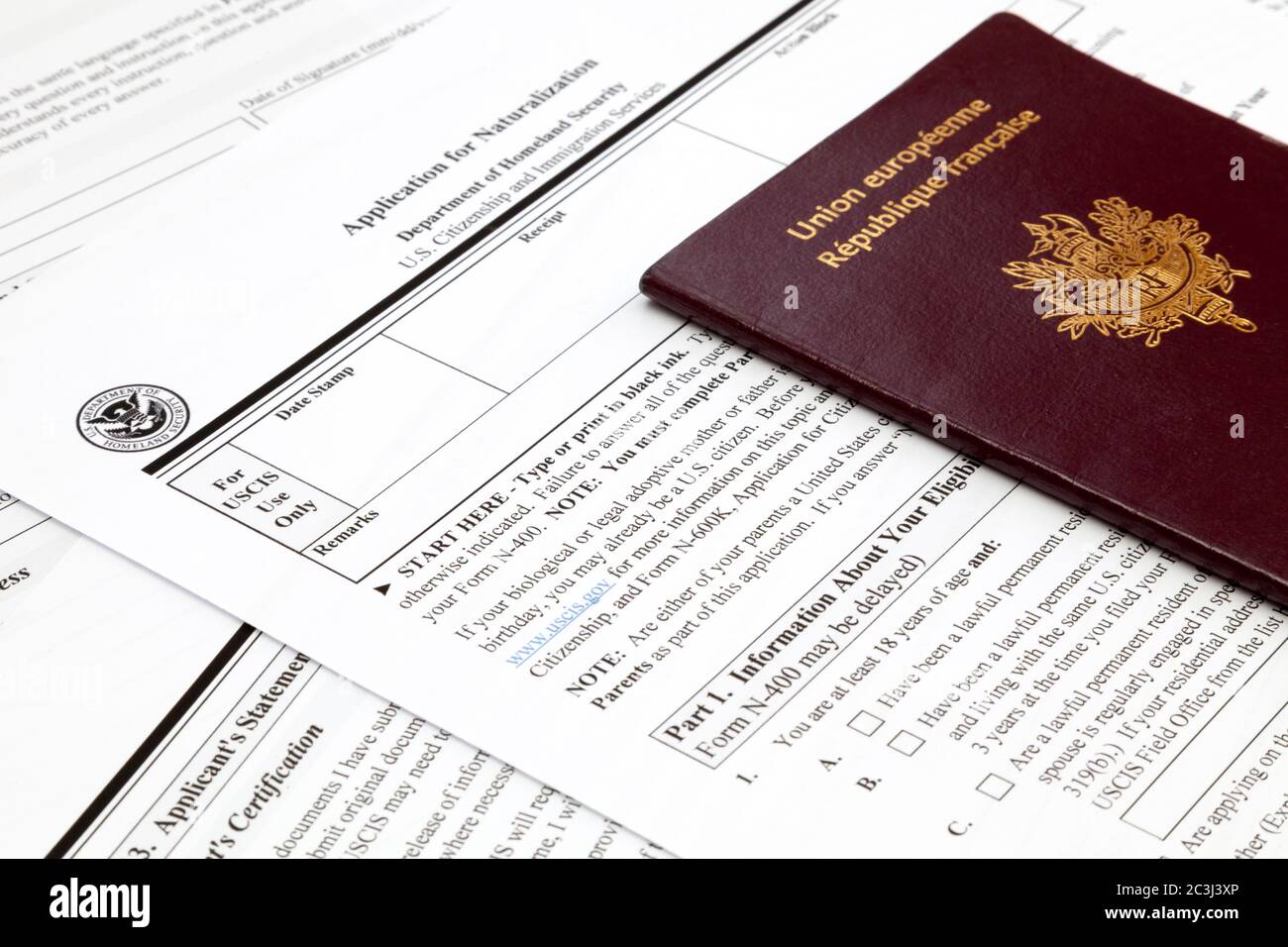 Ein französischer Pass auf dem oberen Teil eines amerikanischen Einbürgerungsantrags. Stockfoto