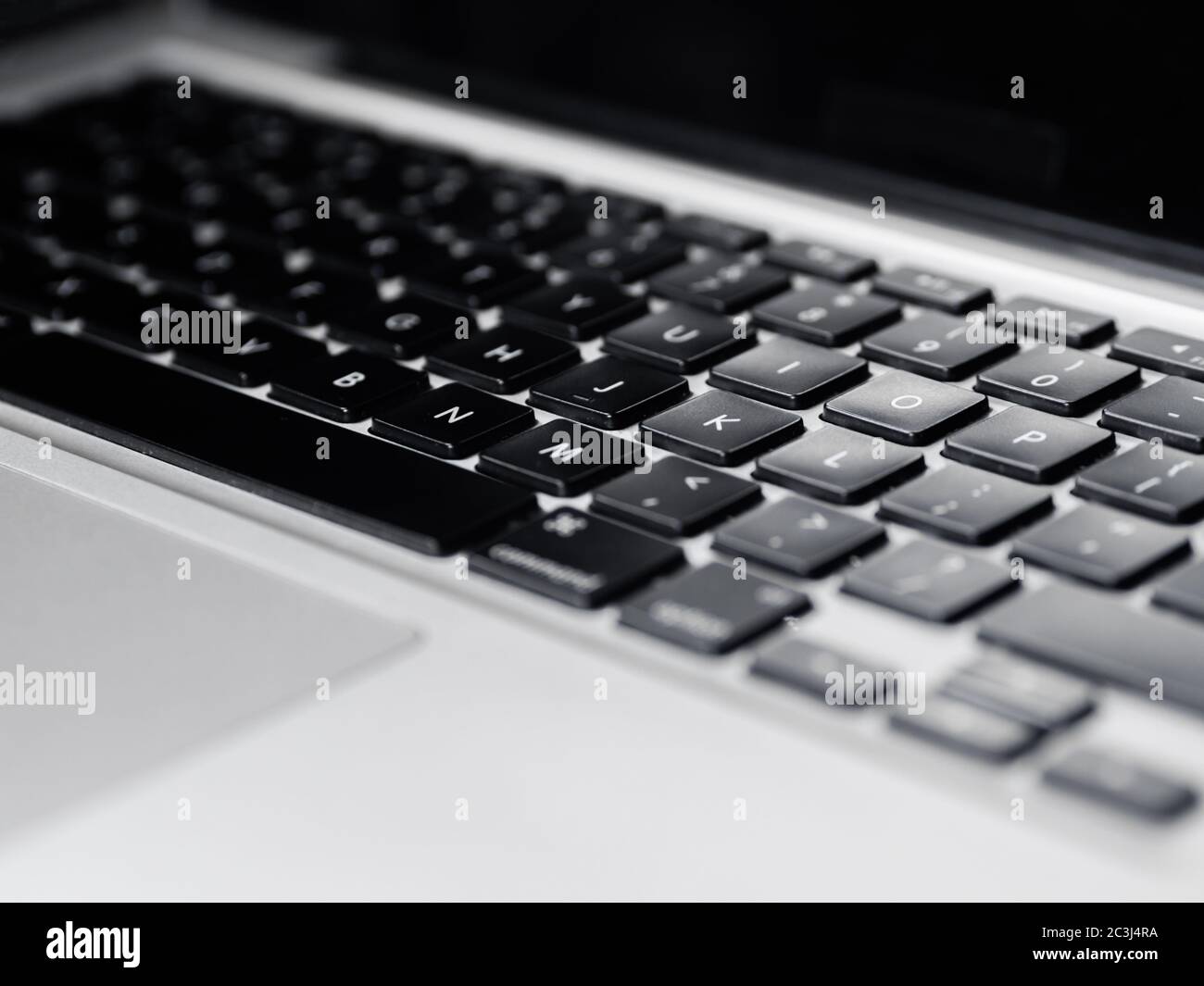 Schwarze qwerty-Tastatur eines grauen Laptops in Nahaufnahme Stockfoto