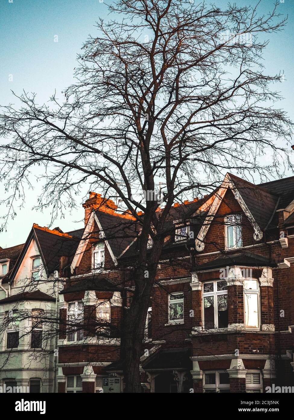 Vertikale Aufnahme von alten Backsteinhäusern mit weißen Fenstern Stockfoto