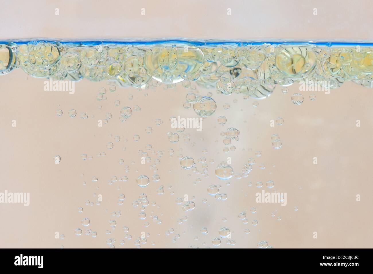 Öl bläht im Wasser mit beigem Hintergrund. Stockfoto