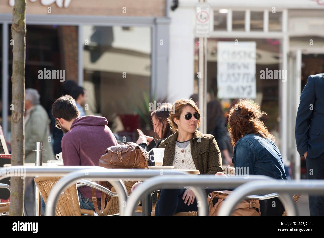 Zwei Frauen, die die Sonne genossen, saßen draußen in Canterbury, Kent. Stockfoto