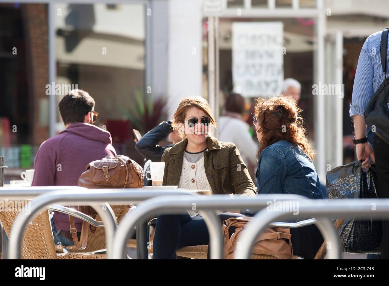 Zwei Frauen, die die Sonne genossen, saßen draußen in Canterbury, Kent. Stockfoto