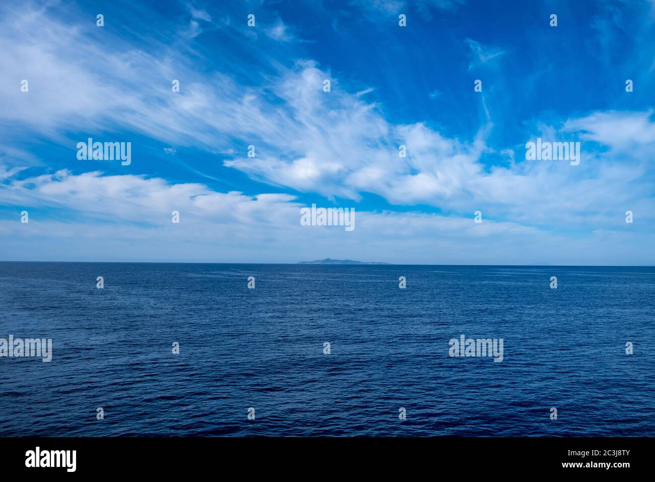 Blaues Meer und Himmel Hintergrund, blaue Schattierungen Horizont. Weiße Wolken am klaren Himmel über der Wasseroberfläche. Ruhiges Meer mit Wellen. Ägäisches mittelmeer Stockfoto