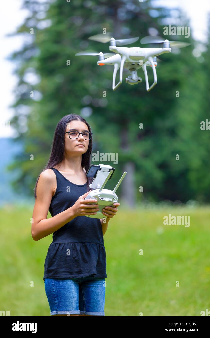 Teenager-Mädchen Kontrolle Drohne mit Fernbedienung und Spaß im Sommer. Konzentrieren Sie sich auf ihr Gesicht. Stockfoto