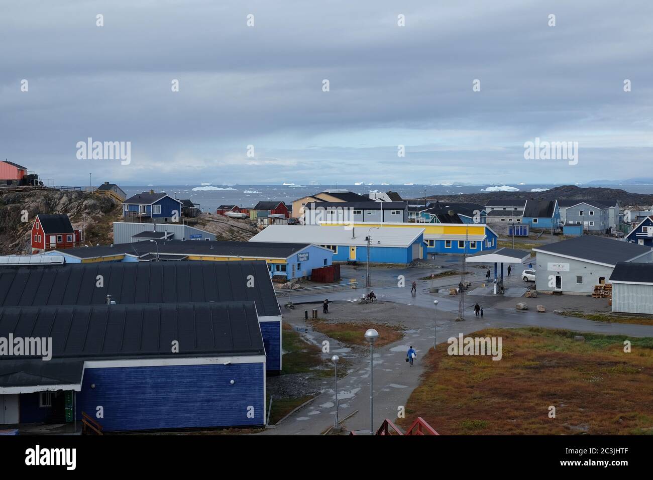 Grönländer leben weiter, während riesige Eisberge in Disco Bay segeln. Stockfoto