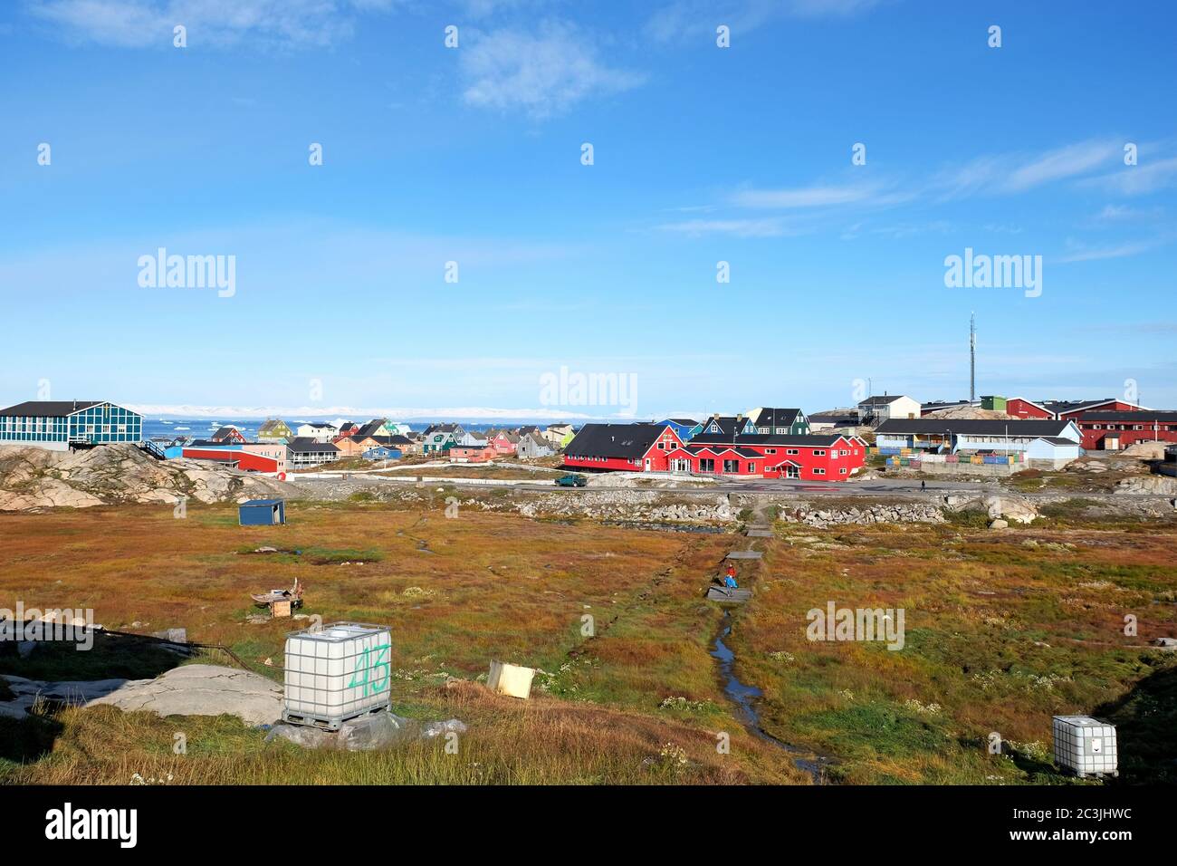 Grönländer leben weiter, während riesige Eisberge in Disco Bay segeln. Stockfoto