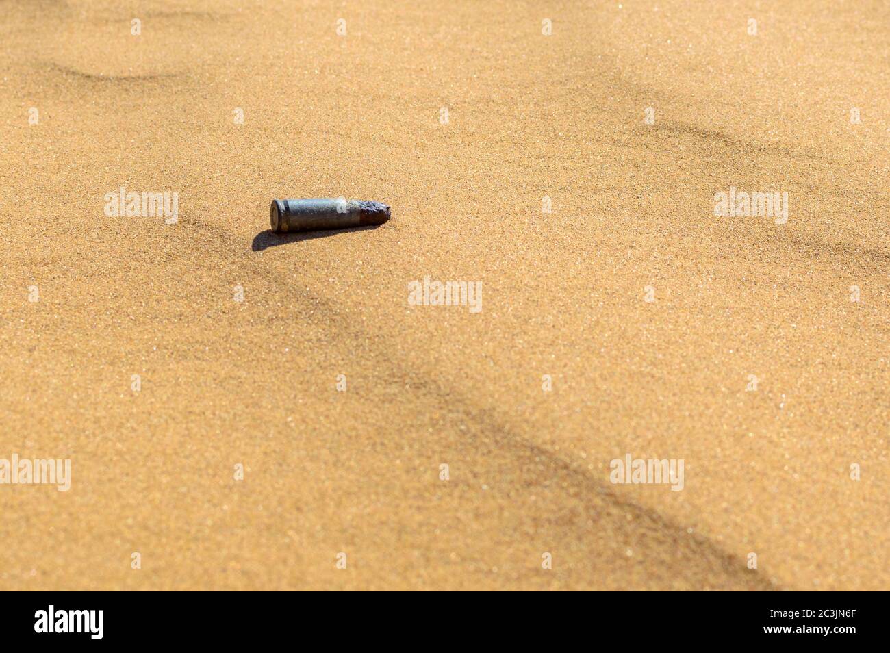 Alte rostige Patronenhülsen im Sand schließen. Stockfoto