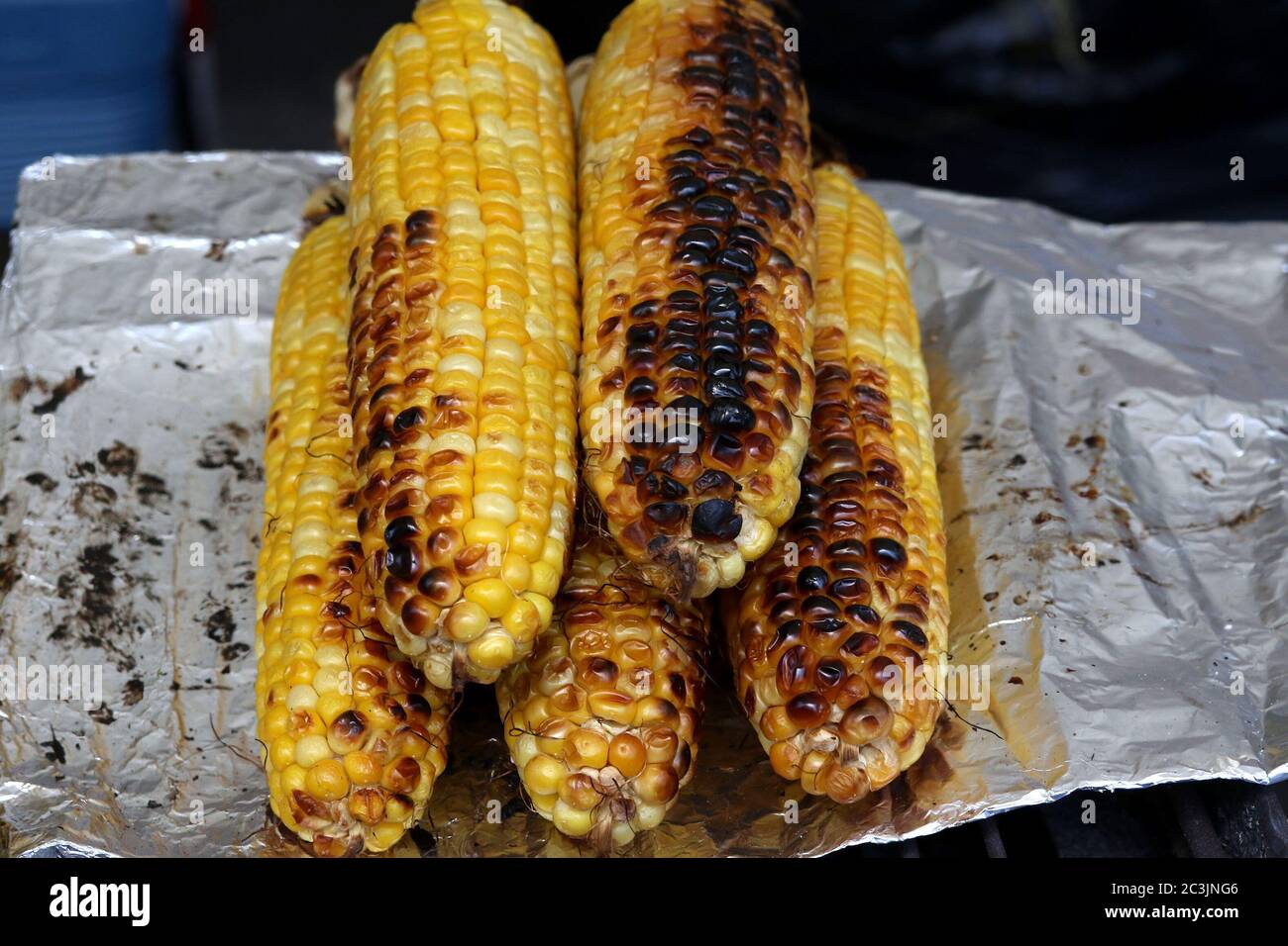 Gegrillter Mais auf dem Cob auf einem verdeckten Grill Stockfoto