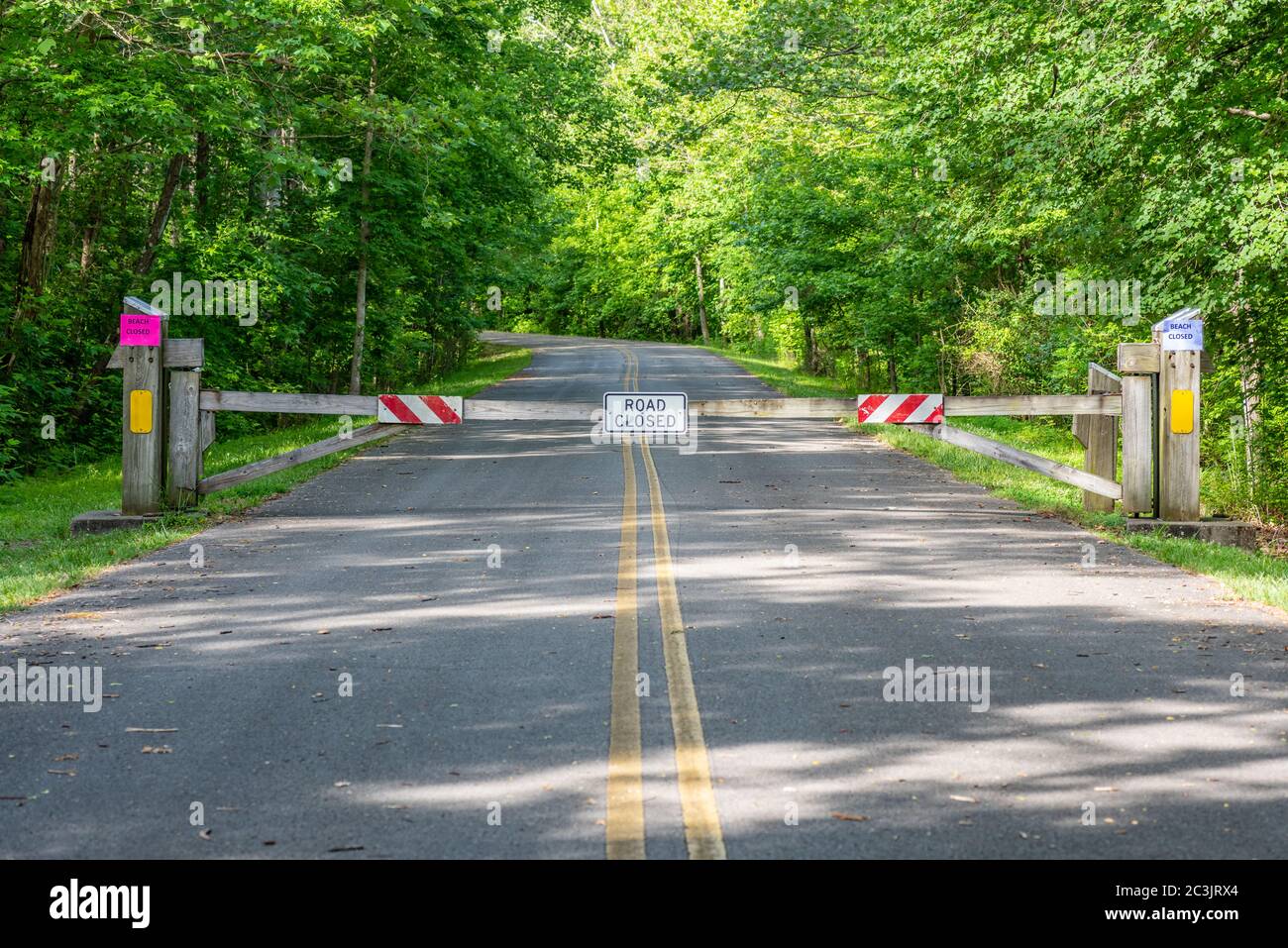 Geschlossenes Tor auf der Straße zu einem Strand in einem nationalen Wald aufgrund der Covid-19 Pandemie Stockfoto