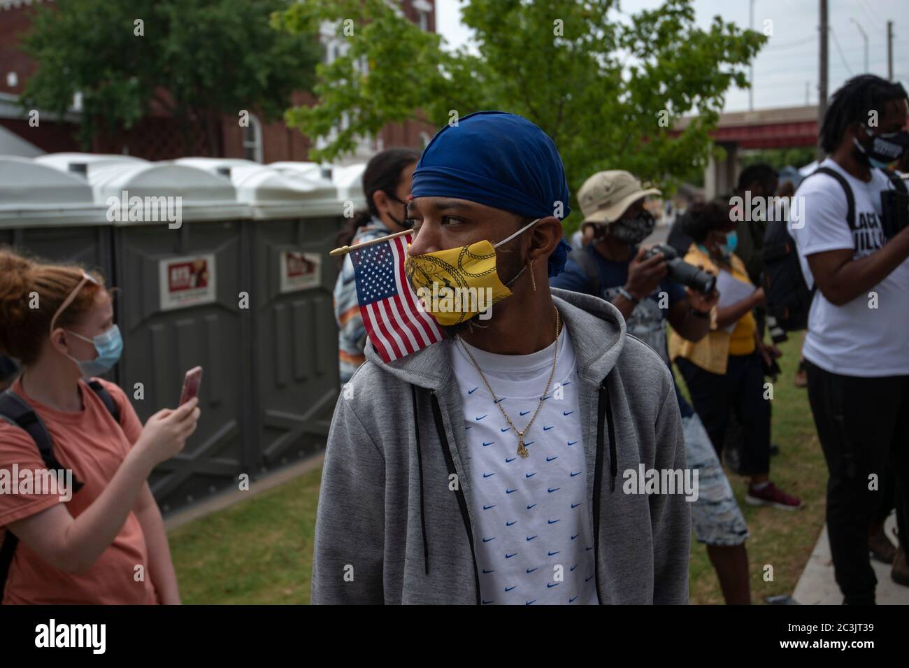 19. Juni 2020, Tulsa, Oklahoma, USA: CECILIO HARRIS, Künstler aus Oklahoma City, hört sich am Freitag eine Rede an, während er eine amerikanische Flagge trägt, die aus einer leeren Schatulle im Greenwood-Viertel ausgeteilt wurde. CECILIO und andere Freiwillige trugen die Schatulle vom Bezirk Greenwood zum Bundesgericht, um eine 150 Milliarden Dollar schwere Klage einzureichen, die zwei Millionen Kleinunternehmen in ländlichen und marginalisierten Gemeinden dienen sollte. Die Menschen nahmen an der Feier des 11. Juni im historischen Greenwood-Viertel von Tulsa, Oklahoma, Teil, wo sich Amerikas Black Wall Street befindet, die 155 Jahre seit der Emancipation Procl steht Stockfoto