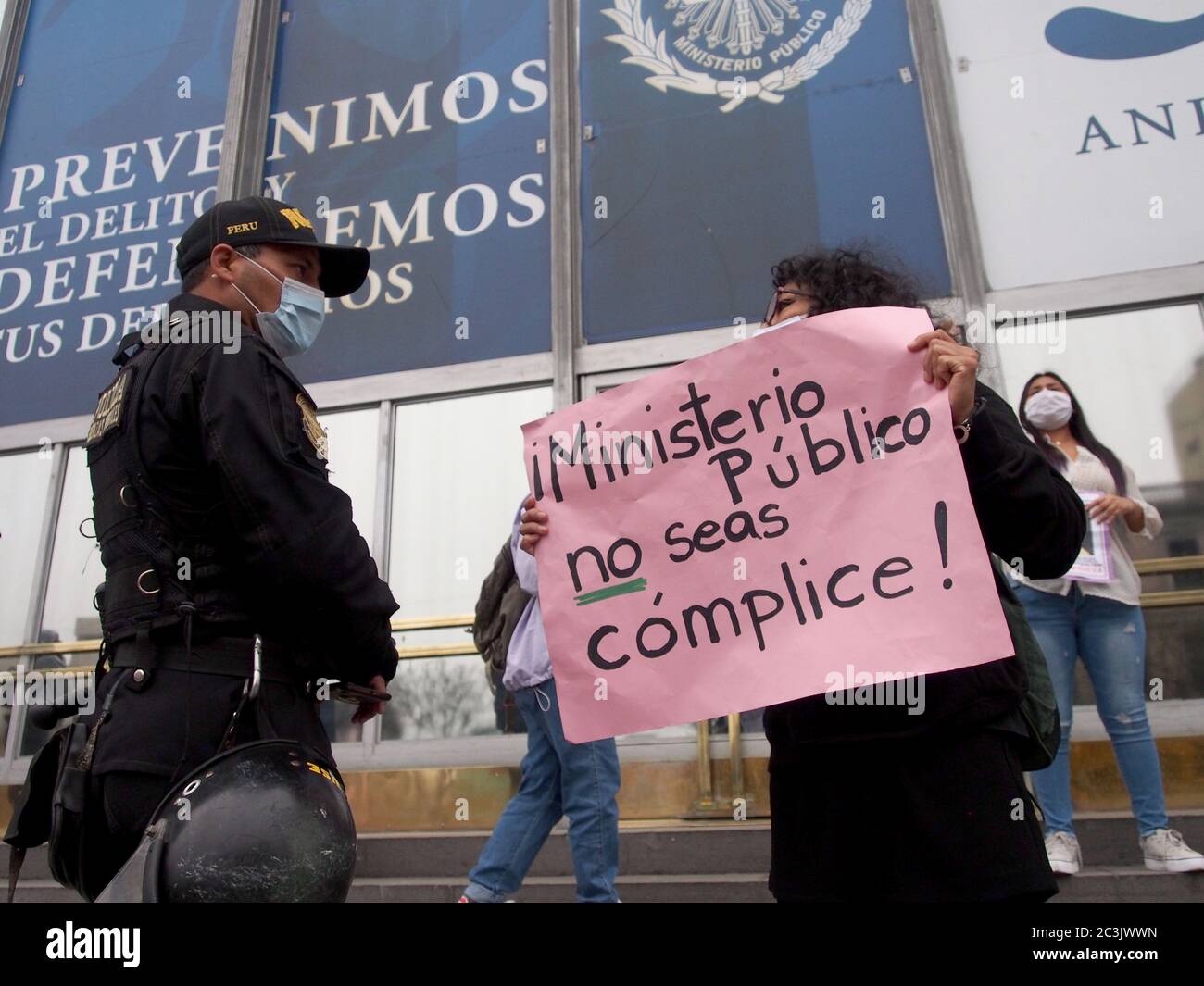 Polizist und ein Mädchen, wenn feministische Demonstranten mit Masken, wegen Covid-19, organisiert ein Sit-in vor der Staatsanwaltschaft´s Lima, aus Protest gegen Gewalt und Feminizide Stockfoto