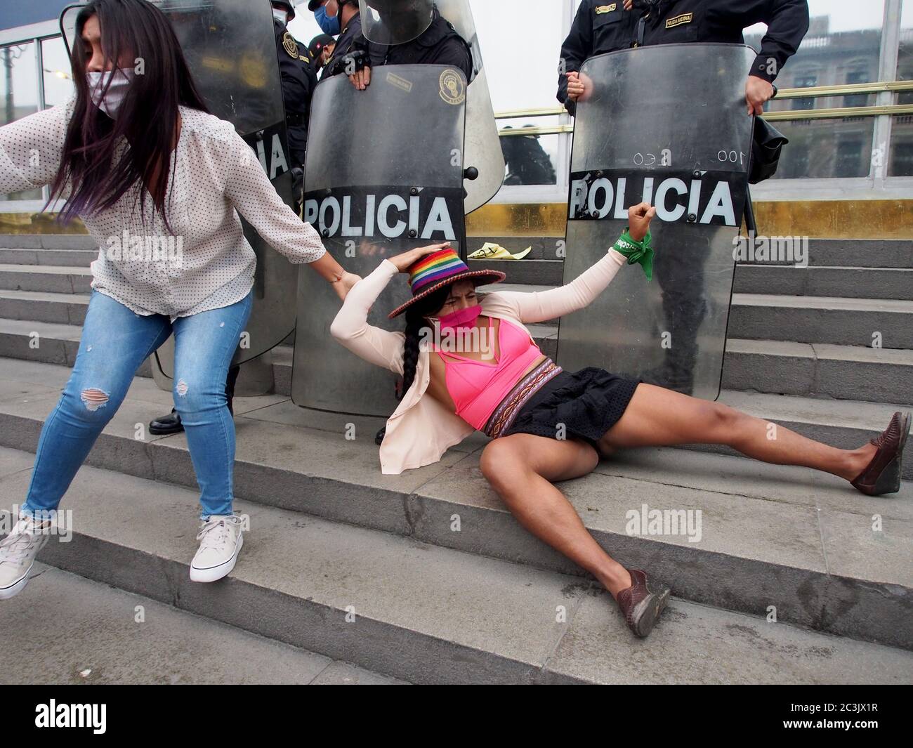 Frauen, die von der Polizei geschlagen wurden, als feministische Demonstranten, die Masken benutzen, wegen Covid-19, ein Sit-in vor der Staatsanwaltschaft´s Lima organisieren, um gegen Geschlechtergewalt und Feminizide zu protestieren Stockfoto