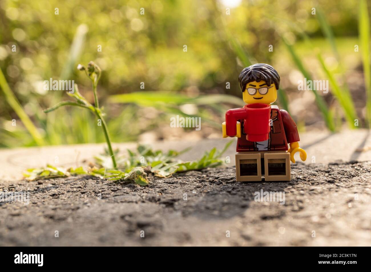 POZNAN, POLEN - 03. Mai 2020: LEGO Mann Figur mit Sonnenbrille sitzt auf  dem Boden und trinkt Kaffee aus einem Becher, während er eine Pause an  einem sonnigen Tag macht Stockfotografie - Alamy