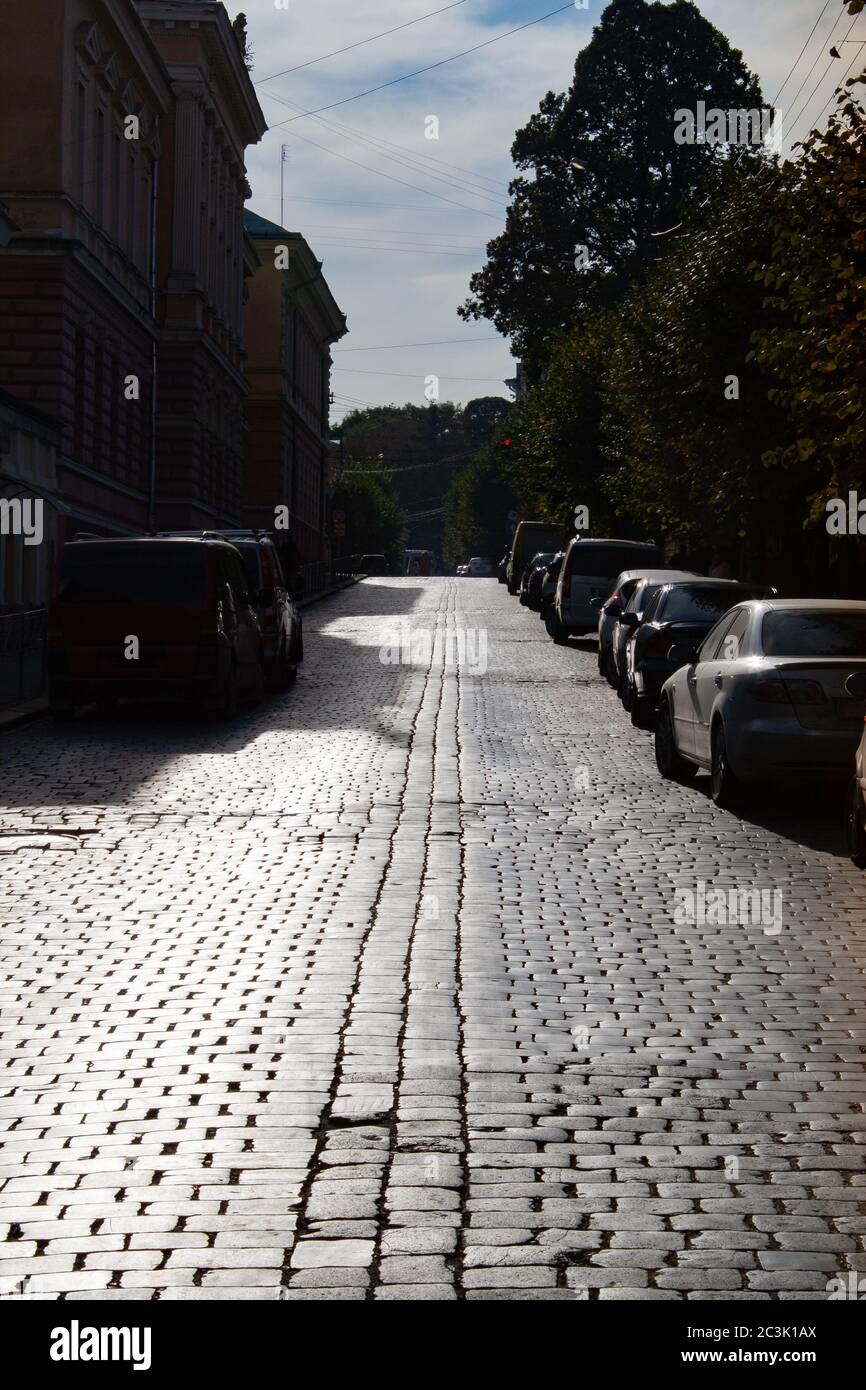 Pflastersteine im Gegenlicht. Eine gepflasterte Straße, die sich in die Ferne erstreckt. Stockfoto