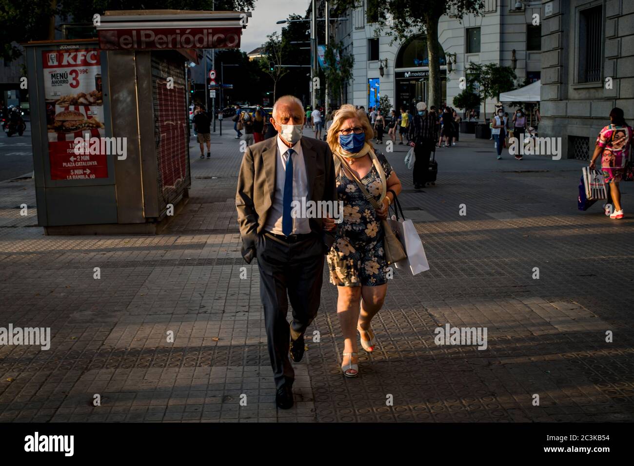 20. Juni 2020, Barcelona, Katalonien, Spanien: Ein Paar mit Gesichtsmasken geht bei Sonnenuntergang den Platz Catalunya in Barcelona hinunter. Am Sonntag, dem 21. Juni, wird Spanien in die "neue Normalität" eintreten und nach drei Monaten wird der Alarmzustand zu Ende gehen. Quelle:Jordi Boixareu/Alamy Live News Stockfoto