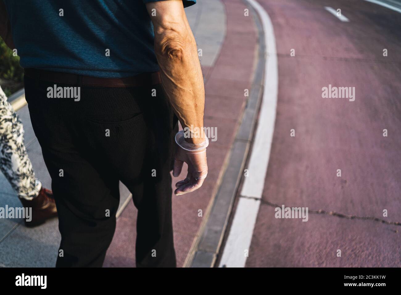 Mann mit transparenten Latexhandschuhen, der auf der Straße steht Stockfoto