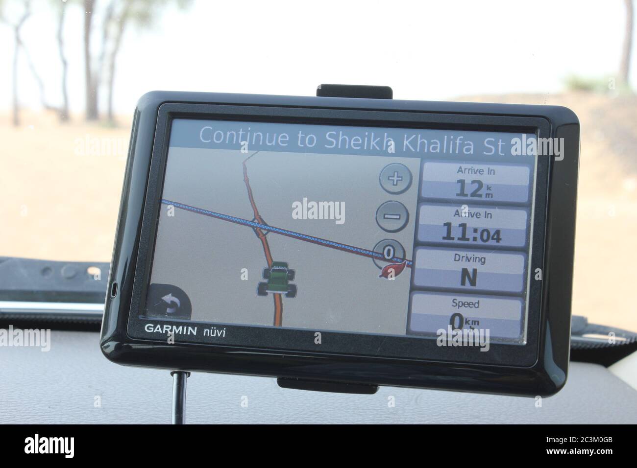 GPS-Einheit (Navi) auf der Windschutzscheibe eines SUV, der in der arabischen Wüste fährt. Stockfoto