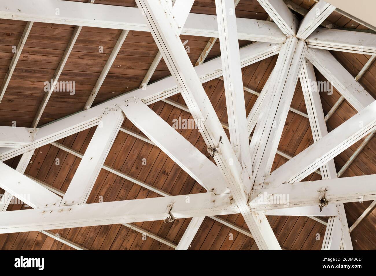 Innenkonstruktion von Holzdach mit weißen Trägern Stockfoto