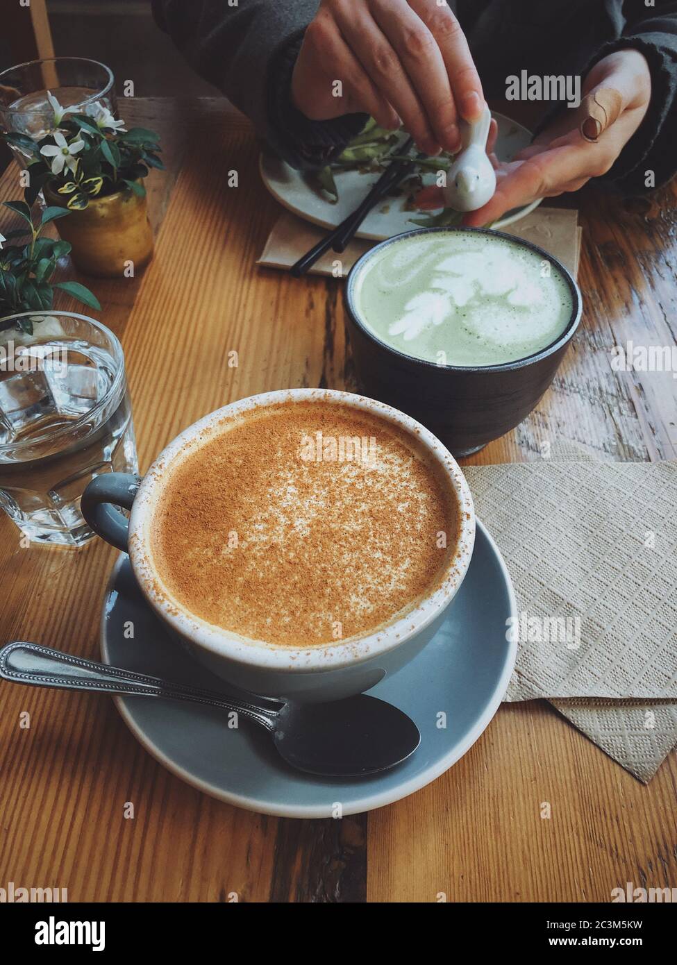 Vertikale Aufnahme von zwei Tassen Kaffee in einem hohen Winkel Ein Holztisch Stockfoto