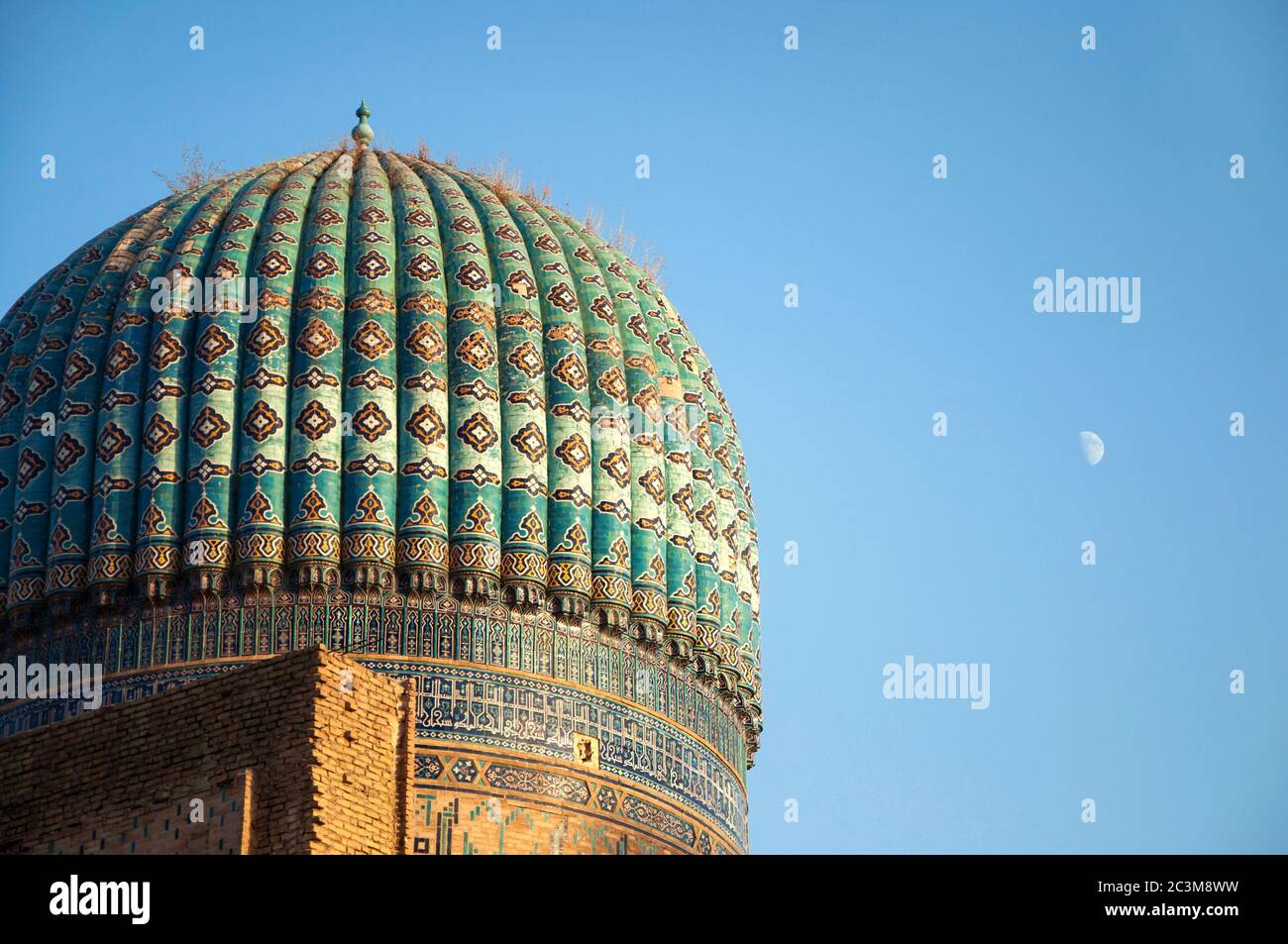 Nahaufnahme der alten Kuppel der Bibi-Khanym Moschee über hellblauem Himmel und Mond, Samarkand, Usbekistan Stockfoto