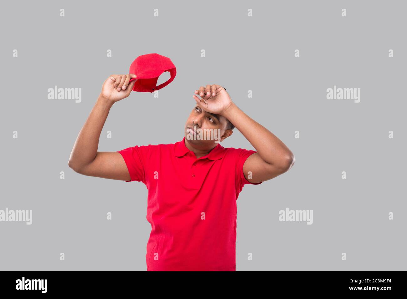 Lieferung Mann Müde Nach Der Arbeit. Indische Lieferung Junge Müde Zeichen. Rote Uniform Stockfoto