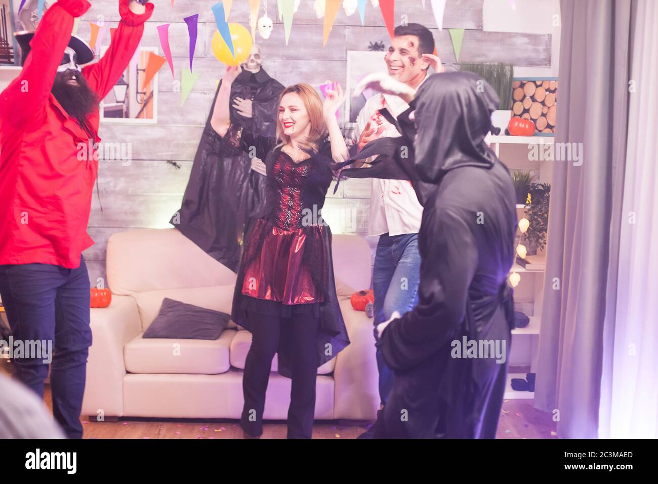 Vampirfrau alughing während der Feier halloween mit ihren Freunden. Stockfoto