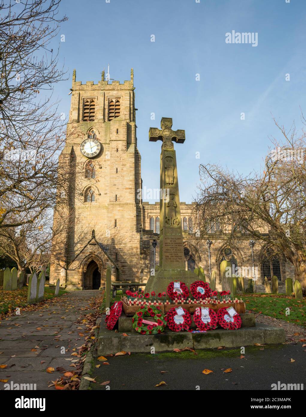 Rote Mohnkränze umkränzen die Basis des Kriegsdenkmals in der St. Gregory's Church, Bedale, North Yorkshire Stockfoto