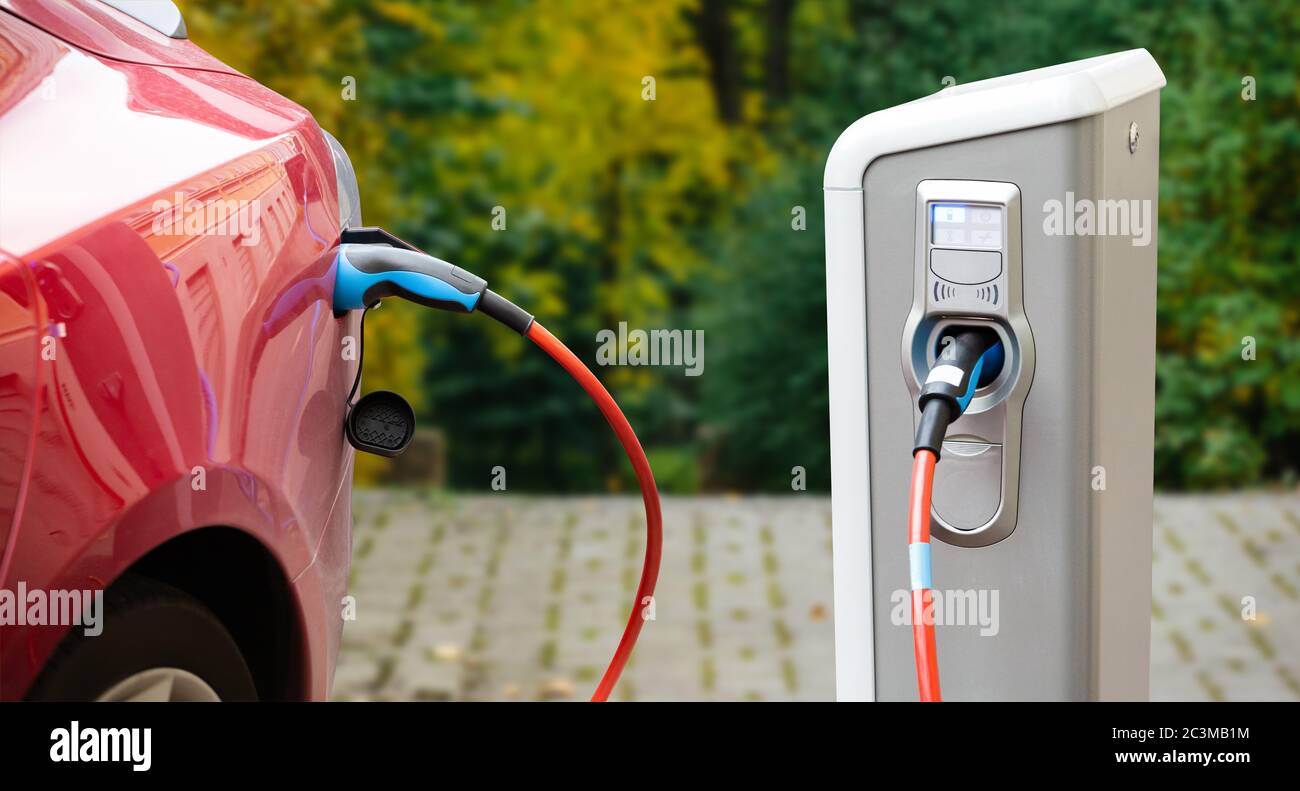 Ladestation auf dem Hintergrund eines Elektroautos. Stockfoto