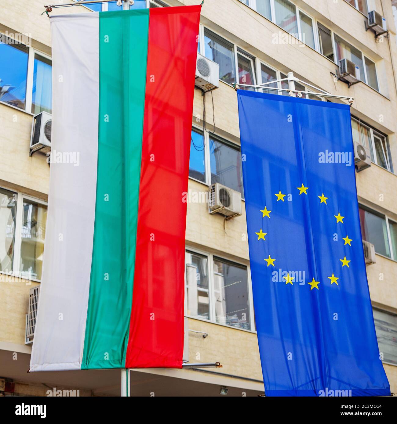 Bulgarische Nationalflagge und EU-Flagge hängen an einem Bürogebäude in der Stadt Sofia, Bulgarien Stockfoto