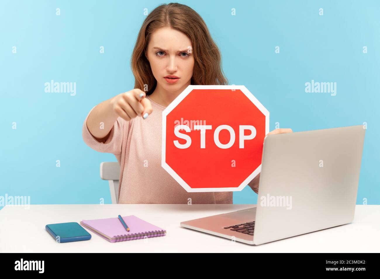 Wütend Frau Chef, Büroangestellte am Arbeitsplatz, halten Stopp-Symbol und zeigt auf Kamera, zeigt rote Verkehrszeichen, negative Prohibition Konzept. In Stockfoto