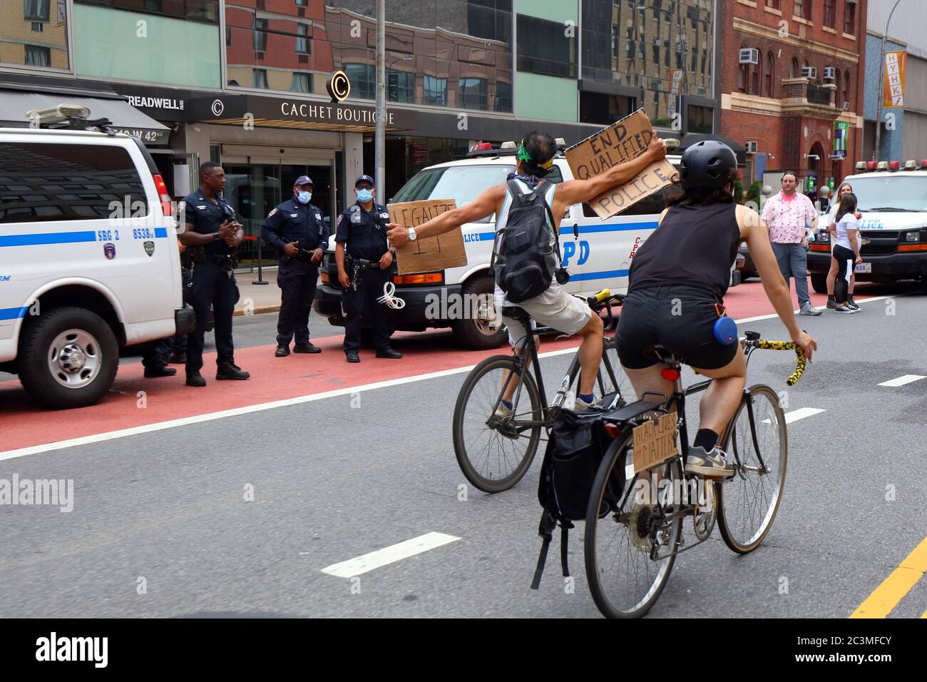 New York, NY, 20. Juni 2020. Eine Person auf einem Fahrrad hält zwei Schilder bei der Polizei, 'qualifizierte Immunität für die Polizei beenden', und 'Legalisieren'. Der Fahrradprotest war eine Solidaritätsfahrt mit Black Lives Matter, die in einer Reihe von amerikanischen Polizeimorden Gerechtigkeit forderte: George Floyd, Breonna Taylor und unzählige andere. Die Fahrradtour wurde von dem Kollektiv Street Riders NYC organisiert. Mehrere tausend Menschen nahmen an der bewegenden Demonstration Teil, die vom Times Square, Harlem und Battery Park aus ging. Juni 20, 2020 Stockfoto