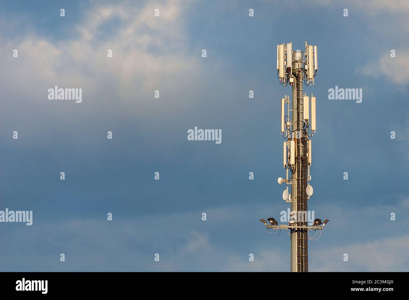 Elektromagnetische Strahlung. Telekommunikationsturm mit 5G- und 4G-Antennen zwischen den Wolken (mit Kopierplatz) Stockfoto