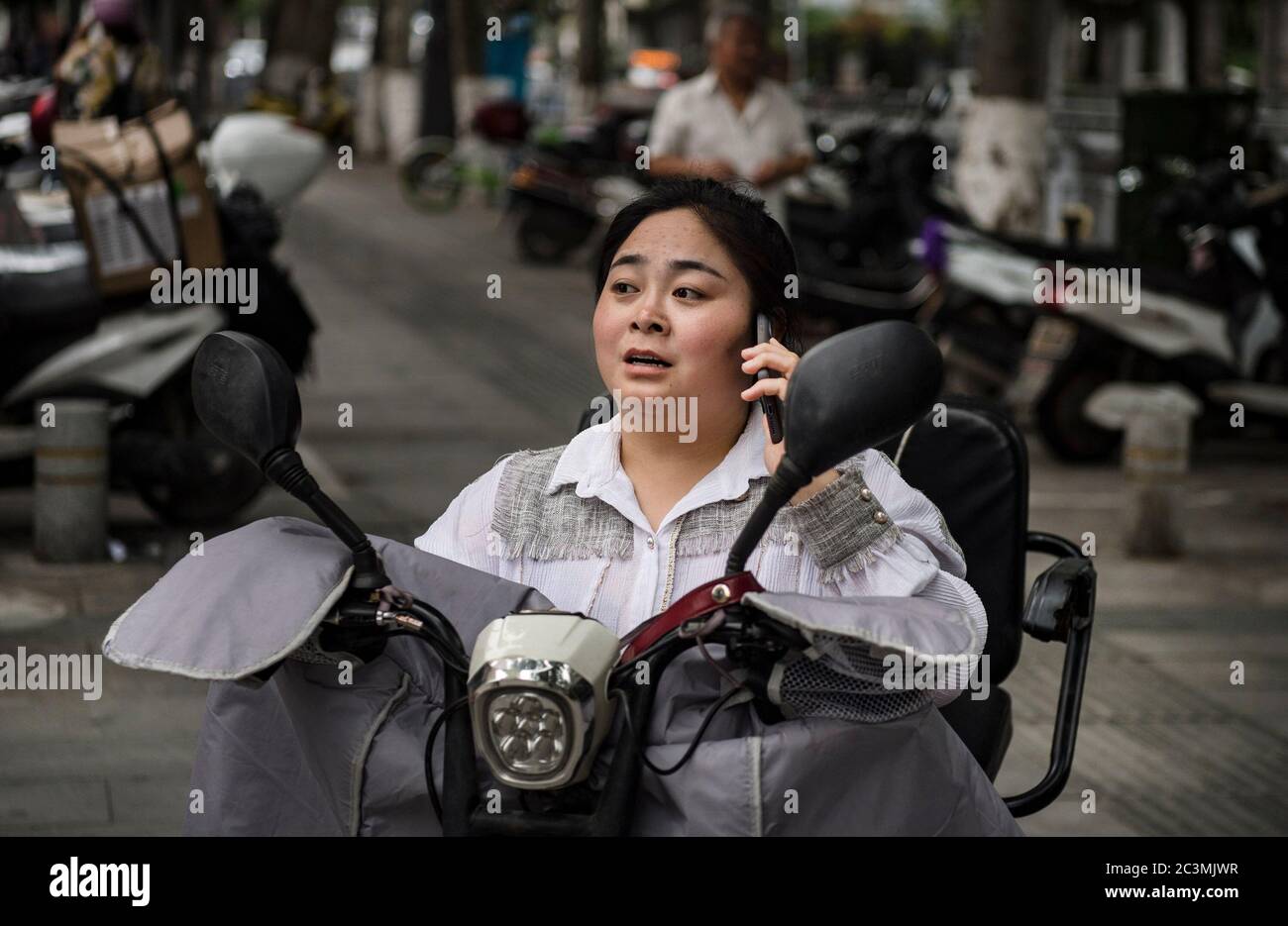 (200621) -- ANKANG, 21. Juni 2020 (Xinhua) -- Li Dan kontaktiert einen Kunden, der eine Bestellung über WeChat getätigt hat, bevor er Produkte im Dorf Wenhua im Bezirk Hanbin der Stadt Ankang, nordwestlich der chinesischen Provinz Shaanxi, am 19. Juni 2020 liefert. Um die Armut zu überwinden, verlegte Li Zengyi, ein Dorfbewohner im Dorf Wenhua der Stadt Ankang, 1997 seine Familie, einschließlich seiner siebenjährigen behinderten Tochter, in ein provisorisch geführtes Haus auf einem Berg, um Pfirsiche zu kultivieren. Li Wei, der ältere Sohn von Li Zengyi, ging nach dem Abschluss der Mittelschule zur Arbeit in der südchinesischen Provinz Guangdong, um die Familie zu unterstützen. Stockfoto