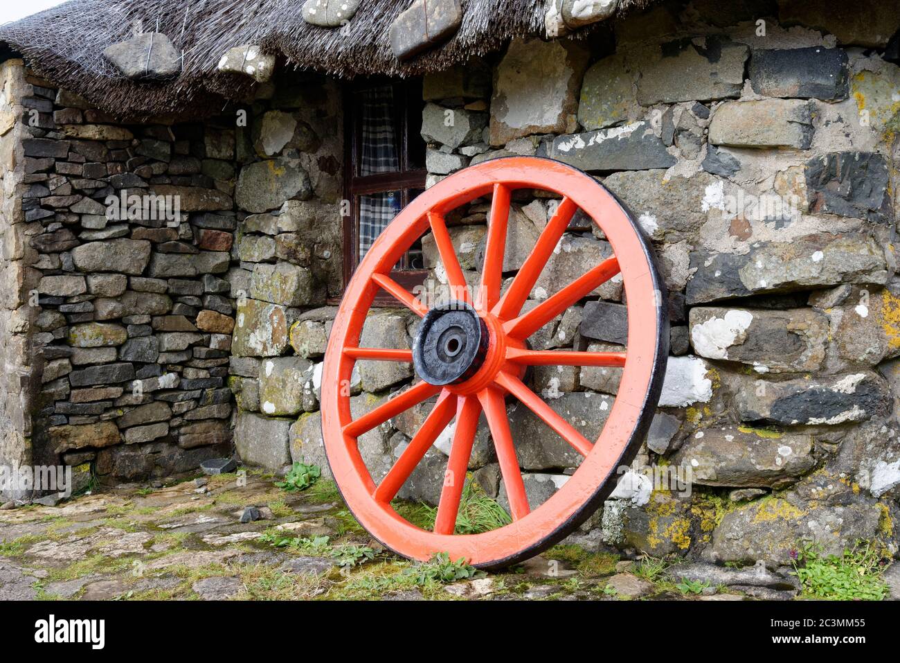 Restauriertes altes Karrenrad vor dem Croft Cottage im Skye Museum of Island Life (Osmigarry Croft Museum), Trotternish, Isle of Skye, Schottland, Großbritannien Stockfoto