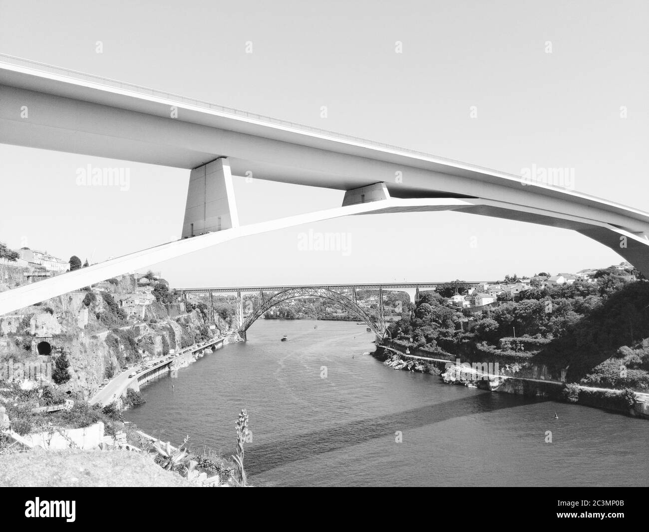 Graustufen Aufnahme einer Brücke über das Wasser unter Ein wolkenverdeckter Himmel Stockfoto