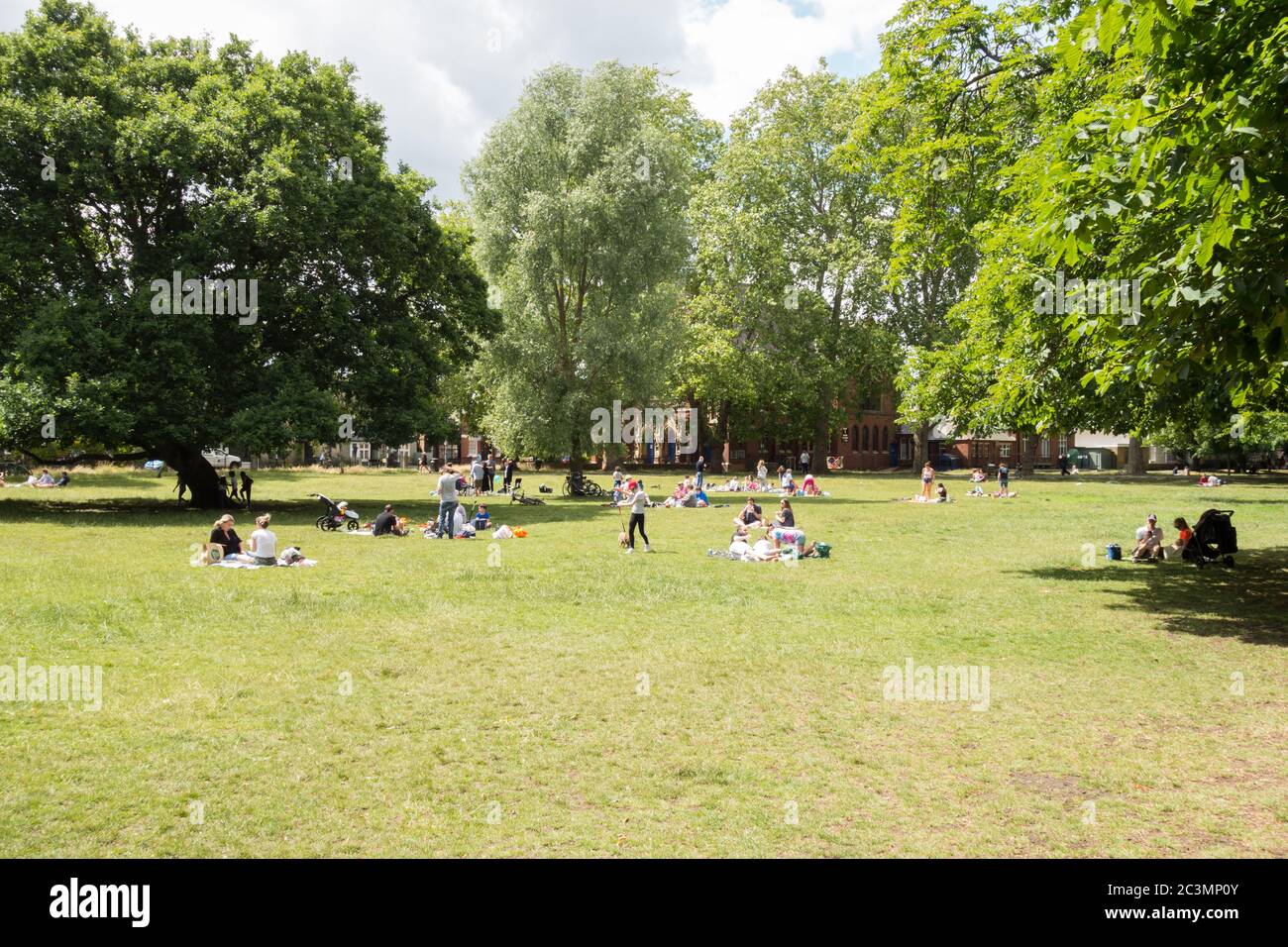 Menschen Sonnenbaden, soziale Distanzierung und Entspannung während Lockdown auf Barnes Common in SW London, Großbritannien Stockfoto
