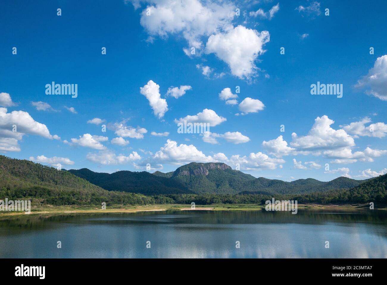 See mit grünen Bergkette in bewölktem blauen Himmel Tag Stockfoto