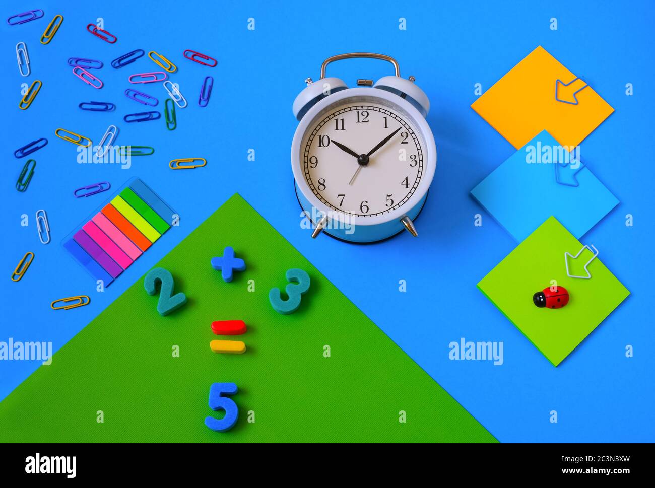 Bunte Papeterie auf blauem monophonischem Hintergrund. Zahlen und Add-ons. Unterricht Kinder Mathematik Mockup, Raum für Text. Bildung. Stockfoto